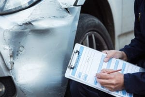 auto-workshop-mechanic-inspecting-damage-to-car
